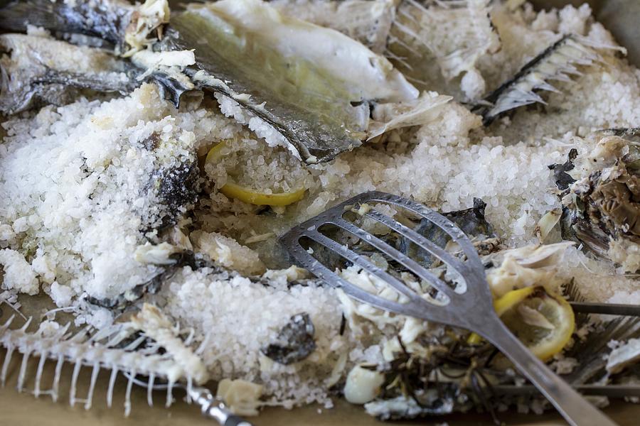 The Remains Of Sea Bream In A Salt Coating On A Baking Tray Photograph by Nicole Godt