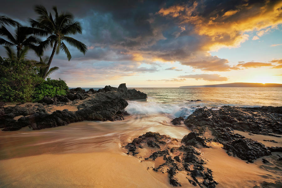 The sun sets over the offshore Kahoolawe Island from Secret Beach ...