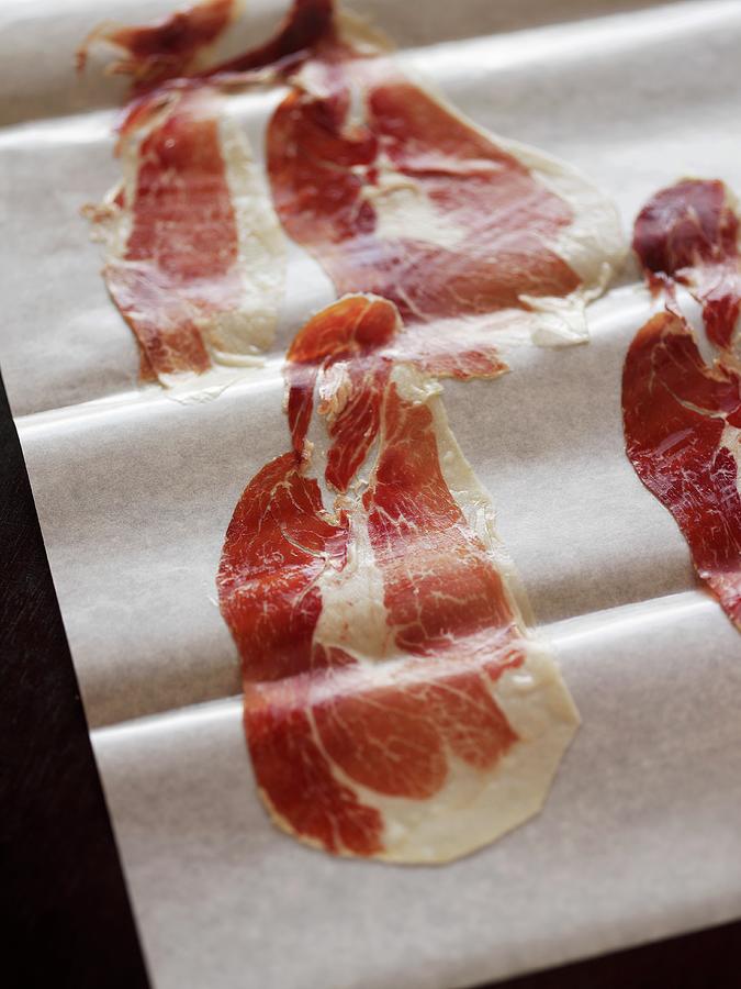 Thin Slices Of Spanish Pata Negra Ham On Parchment Paper Photograph by Mueller, Adrian