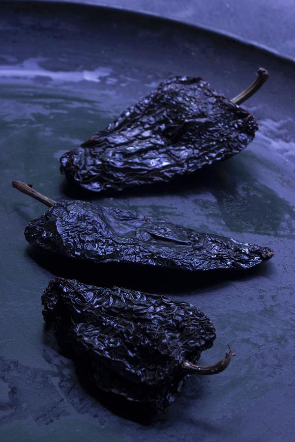 Three Black Jalapeo Chilli Peppers In A Flat Black Bowl Photograph by Charlotte Von Elm