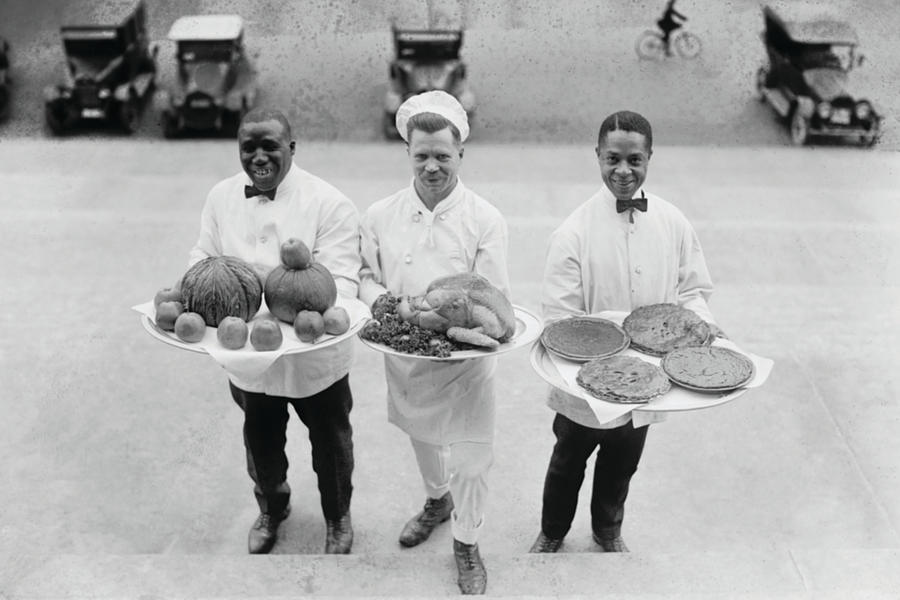 Three Chefs stand on bottom of a line of steps and hold up Thanksgiving platters of Pies, apples and a Turkey Painting by 