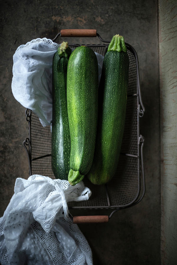 Three Courgettes In A Wire Basket Photograph by Kati Neudert