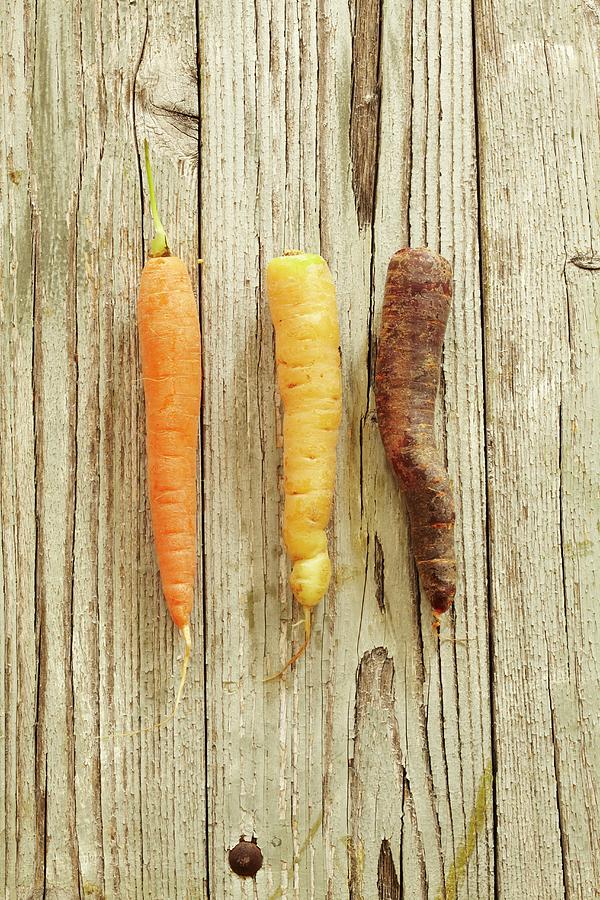 Three Different Carrots On A Wooden Surface Photograph by Kirchherr, Jo