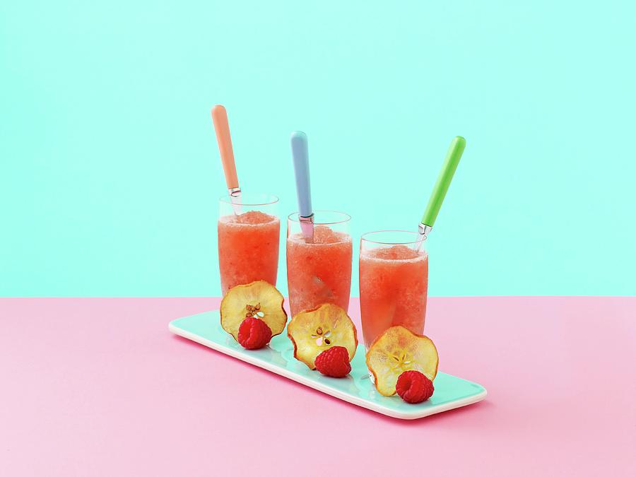 Three Glasses Of Pink Lady Apple Frappe, Decorated With A Slice Of Apple And A Raspberry Photograph by Will Shaddock Photography