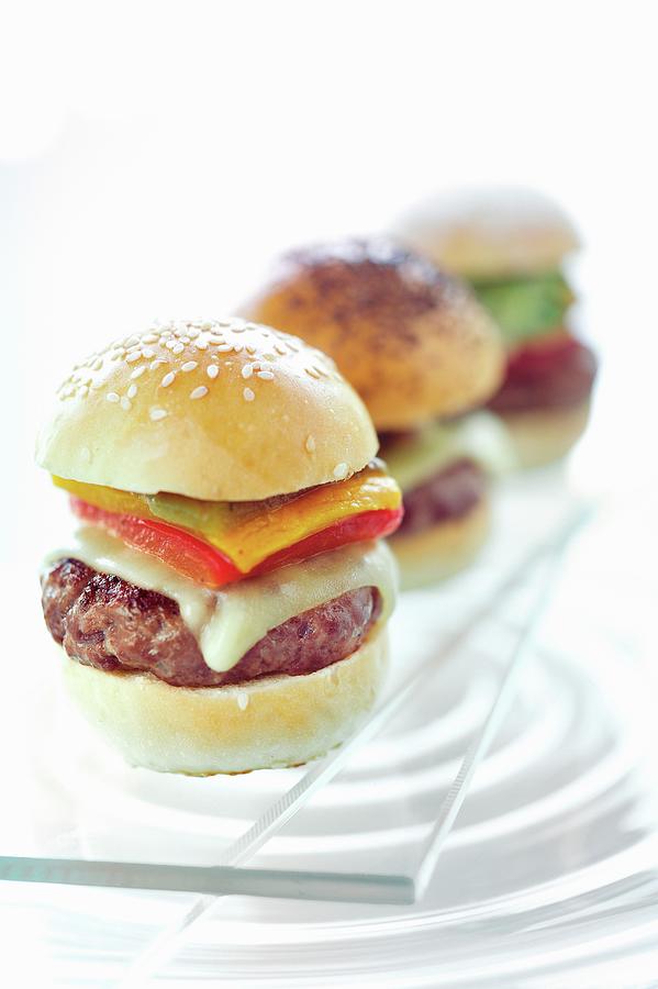 Three Mini Hamburgers In A Row On A Glass Platter Photograph by Kaktusfactory