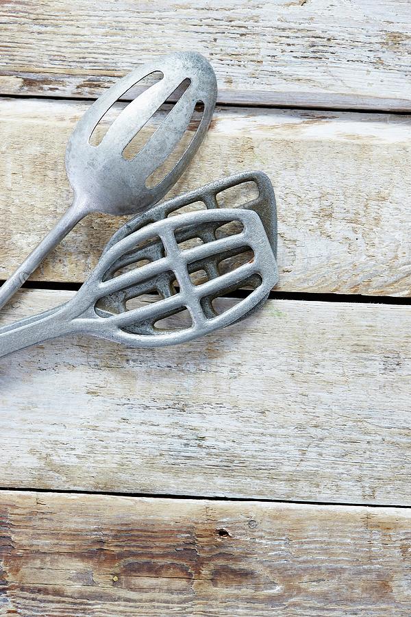Three Old Metal Spatulas On A Wooden Background Photograph by Misha Vetter