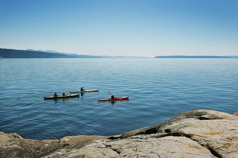 Three People Kayaking On The Coastline Photograph by Francisblack