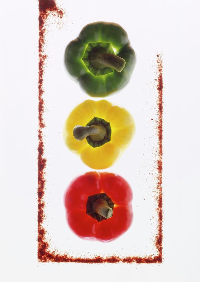 Three Peppers, Backlit, With A Frame Made From Ground Paprika Photograph by Michael Wissing