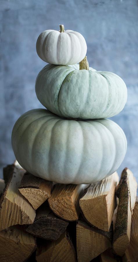 Three Pumpkins, Stacked On Firewood Photograph by Eising Studio
