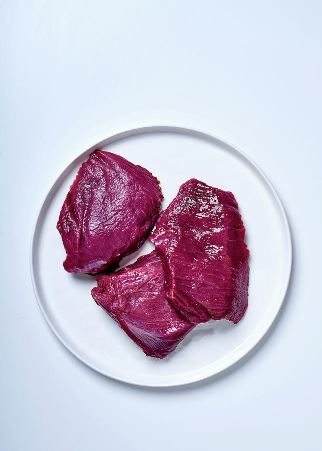 Three Raw Ostrich Steaks On A Plate Against A White Background top View Photograph by Great Stock!