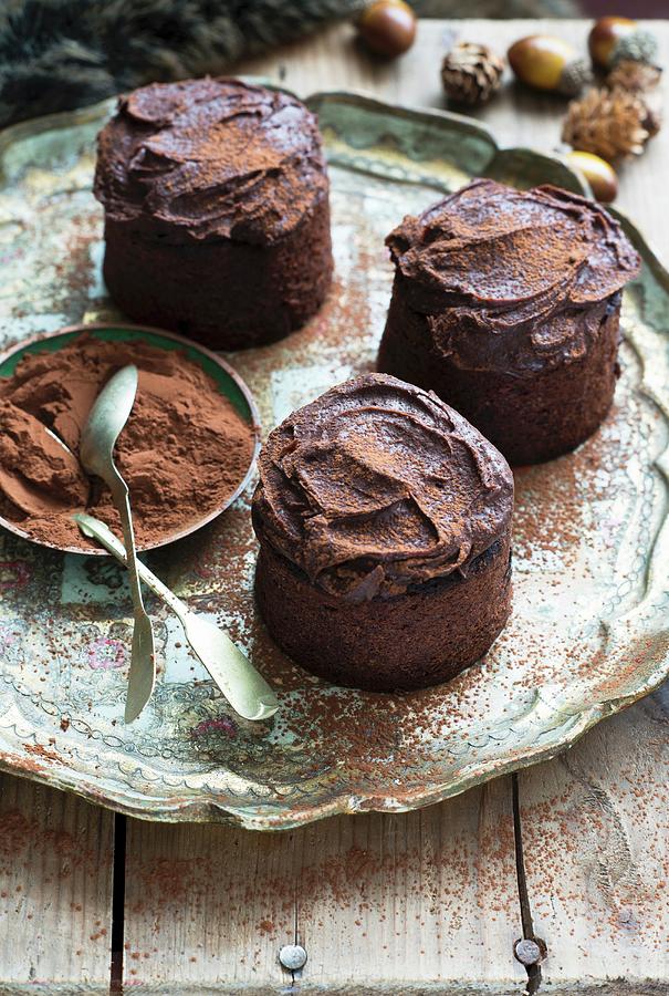 Three Rum And Raisin Cakes With Chocolate Icing For Christmas Photograph by Veronika Studer