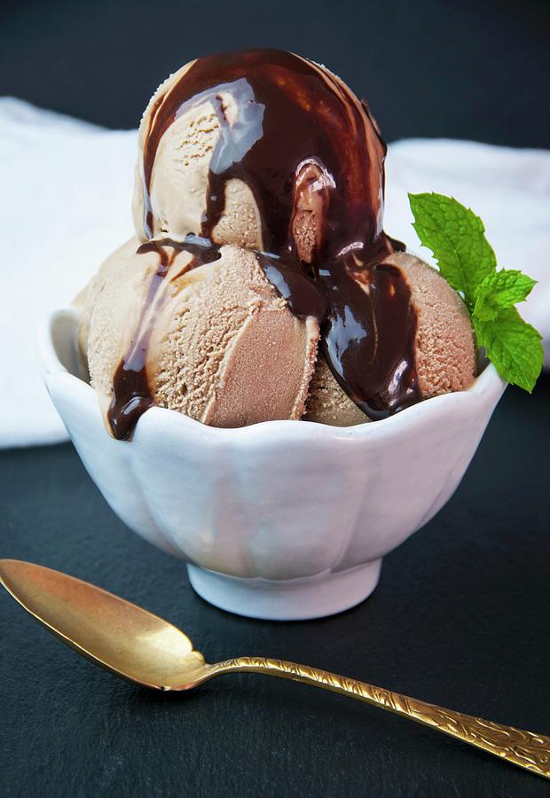 Three Scoops Of Homemade Chocolate Gelato With Chocolate Sauce In A White Bowl Photograph by Jennifer Blume