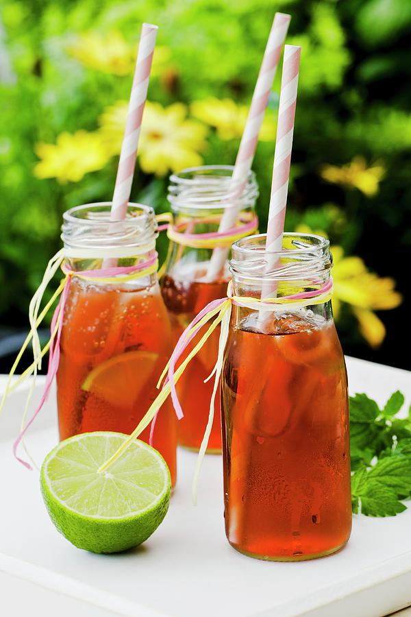 Three Small Bottles Of Iced Tea With Lime And Peppermint On A Tray Photograph by Esther Hildebrandt