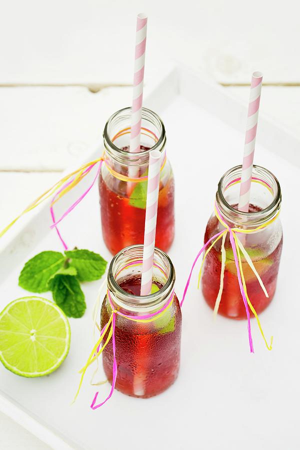 Three Small Bottles Of Iced Tea With Lime And Peppermint On A White Tray Photograph by Esther Hildebrandt
