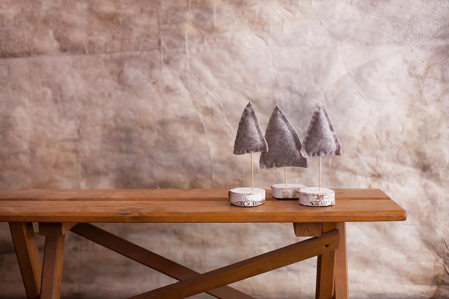 Three Small Felt Christmas Trees On Stands Made From Slices Of Birch Photograph by Alicja Koll