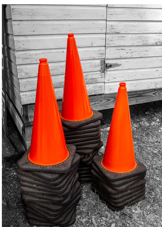 Three Stacks Of Orange And Black Traffic Cones On A Black And White