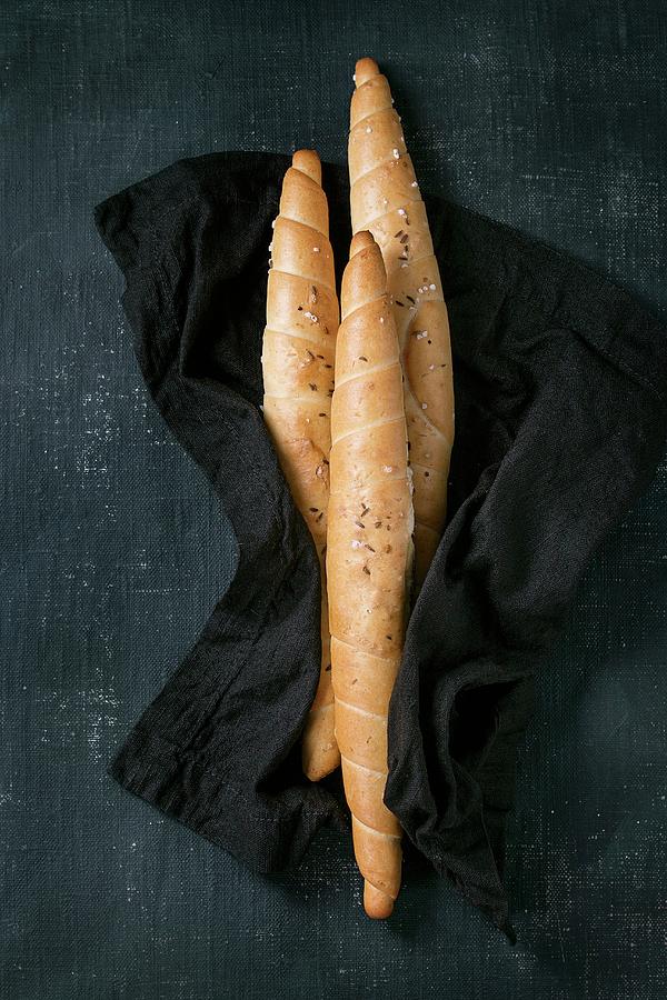 Three Twisted Breads With Salt And Cumin On Black Textile Photograph by Natasha Breen