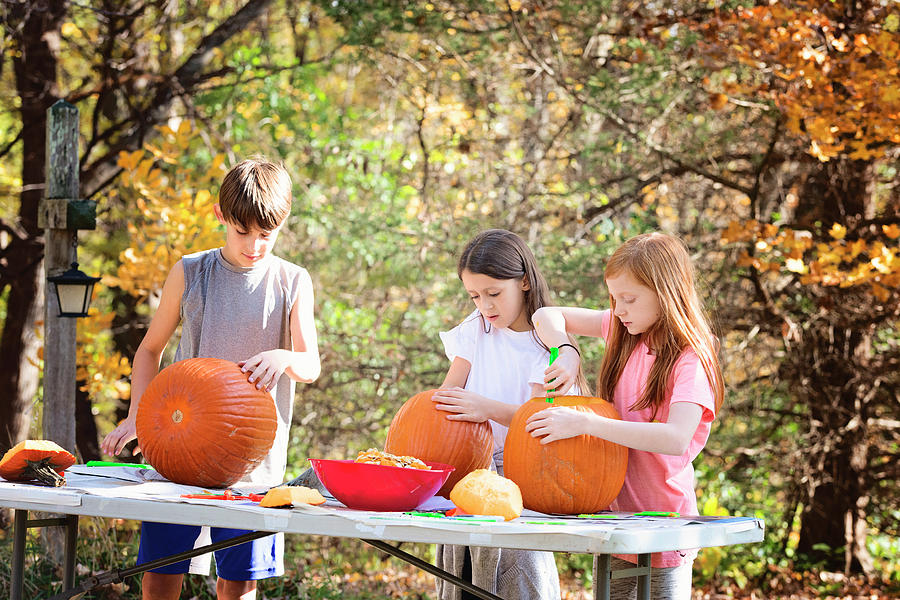 Three Young Children Carving Pumpkins Outdoors Photograph by Cavan ...