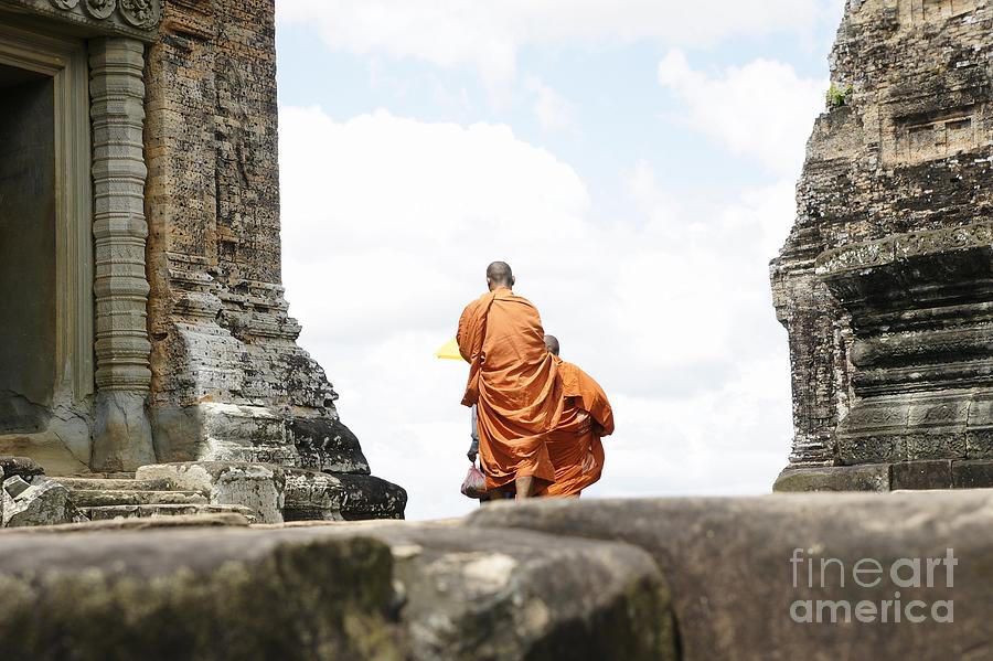  Tibetan monks in orange robes visiting remote Cambodian temples to meditate. Photograph by Joaquin Corbalan