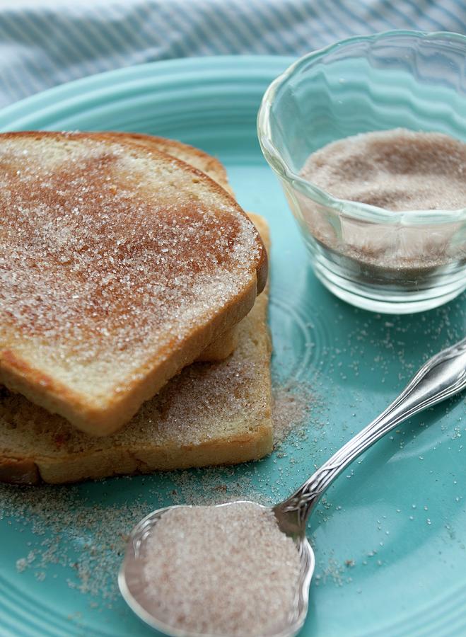 Toast With Cinnamon Sugar On A Blue Plate, With Cinnamon Sugar Mixture In A Glass And On A Spoon Photograph by Campbell, Ryla