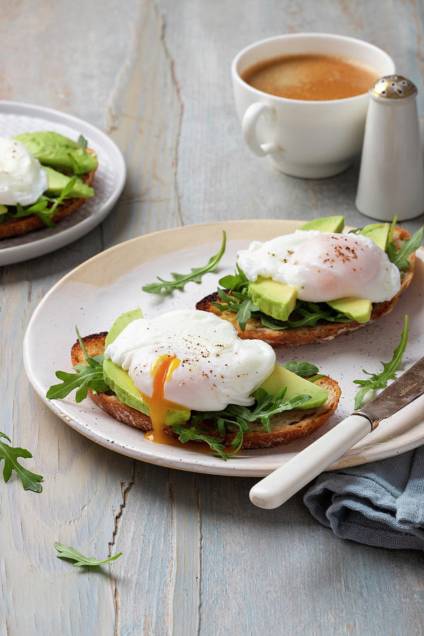 Toasts With Avocado, Rocket And Poached Eggs, Coffee, Rocket Leaves Photograph by Zuzanna Ploch