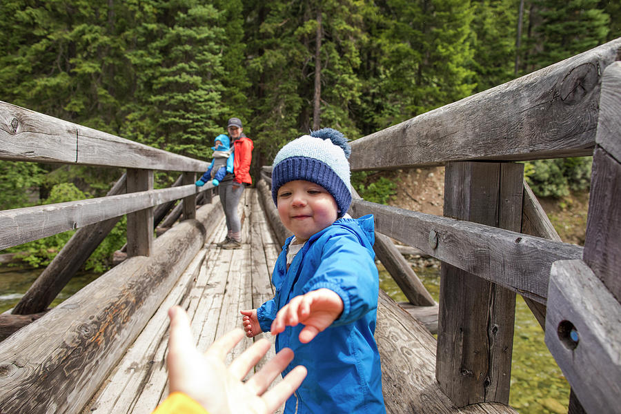 Nature Photograph - Toddler Boy Reaching For Fathers Hand, Safely Cross Wooden Bridge by Cavan Images