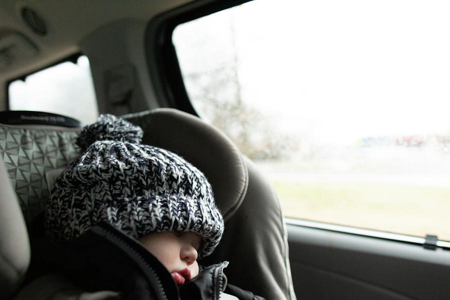Winter Photograph - Toddler Wearing Winter Hat Sleeps While In Carseat Inside Minivan by Cavan Images