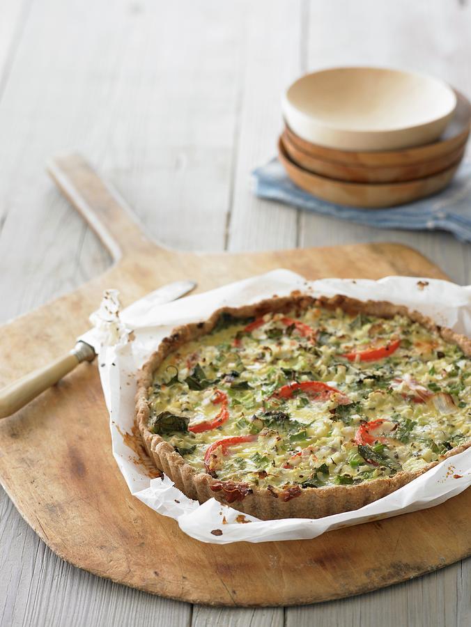 Tomato And Basil Tart On A Piece Of Baking Paper Photograph by Leigh Beisch