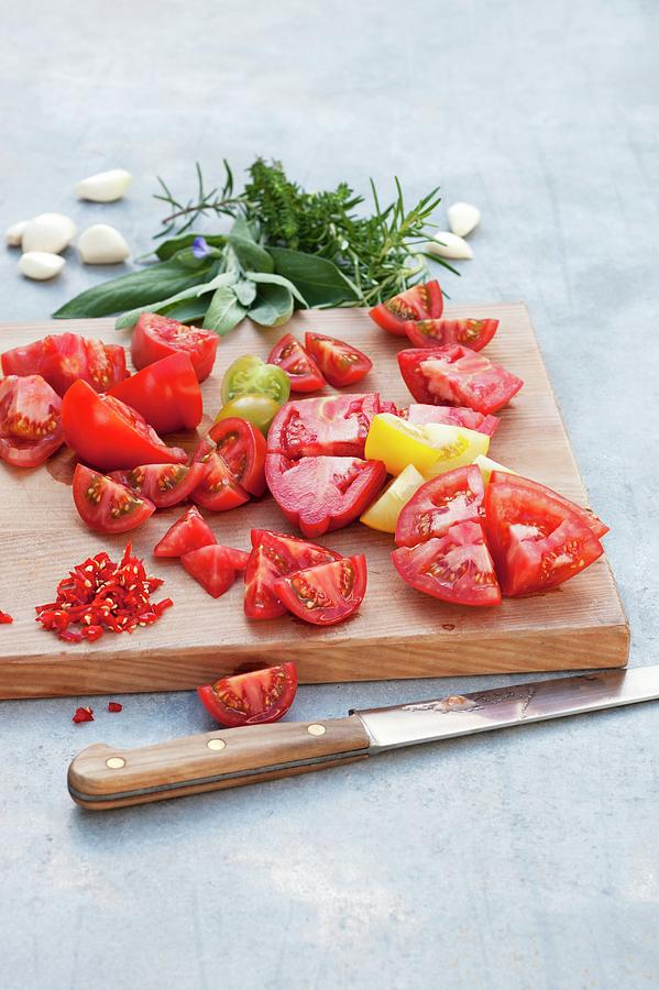 Tomatoes Cut Into Small Chunks On A Wooden Board Photograph by Gerlach, Hans