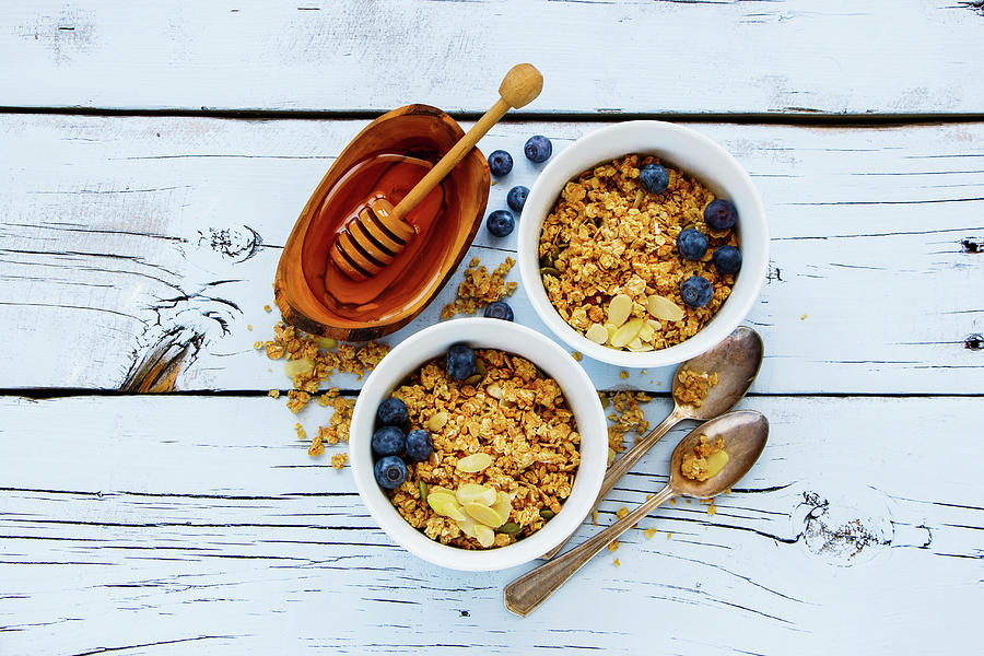 Top View Of Delicious Granola And Healthy Breakfast Ingredients - Honey, Fresh Blueberries And Nuts On White Grunge Background Photograph by Yuliya Gontar