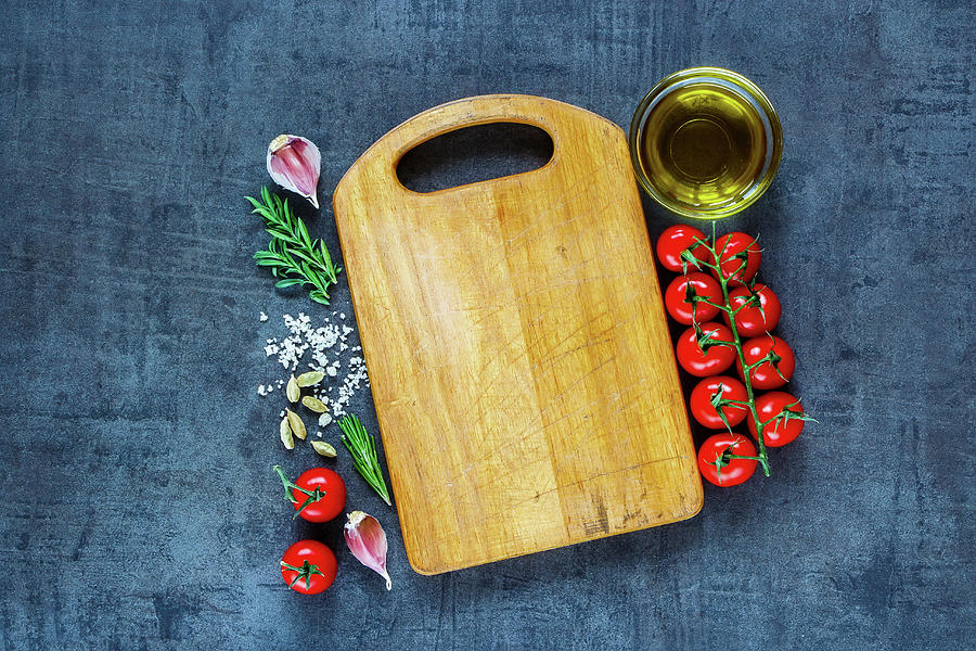 Top View Of Empty Vintage Cutting Board With Organic Tomatoes, Spices And Olive Oil Over Dark Grunge Background Photograph by Yuliya Gontar