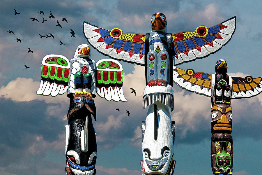Totem Poles against a Cloudy Sky with Flying Birds Photograph by Randall Nyhof