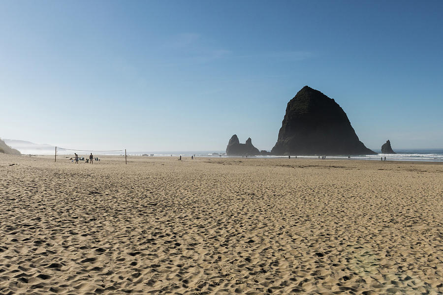 Tourists And Locals Enjoying The Beach With Haystack Rock In Thecannon Beach, Oregon, Usa - October Photograph