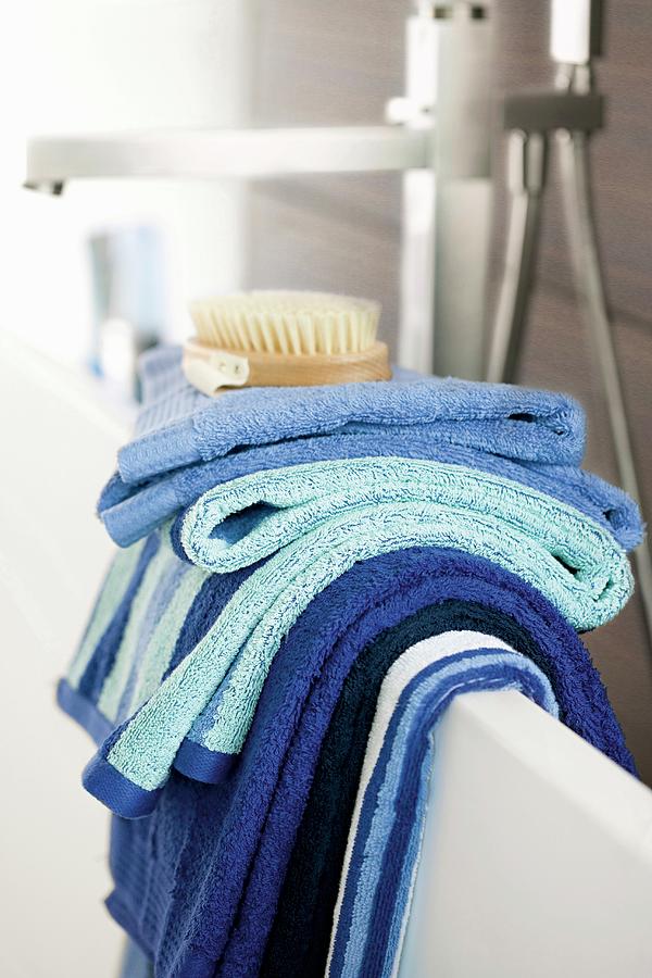 Towels In Shades Of Blue Hanging Over Edge Of Bathtub Photograph by Biglife