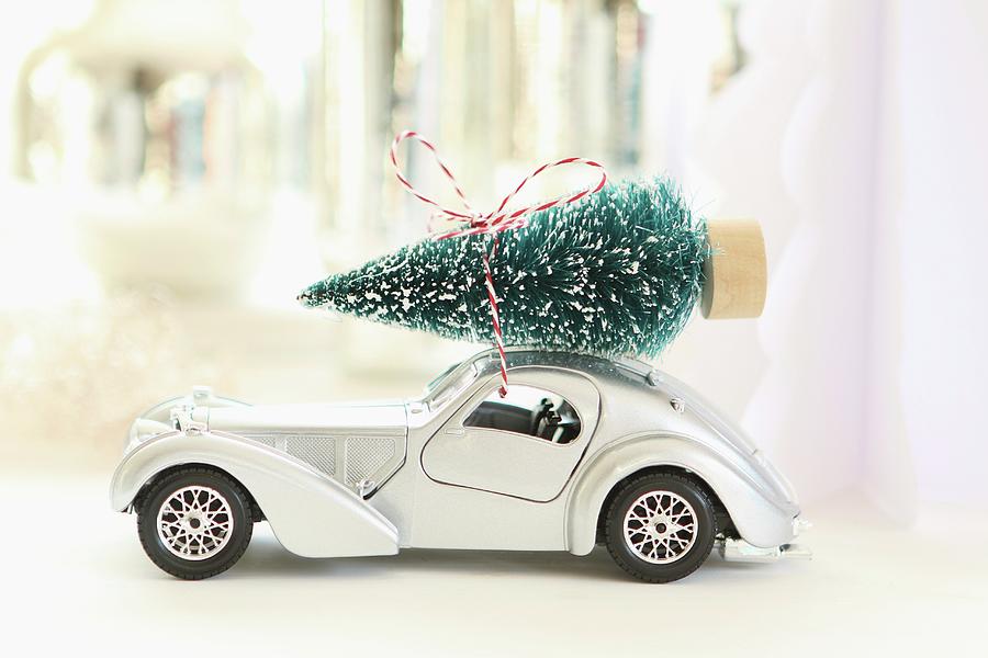Toy Car With Christmas Tree On Roof Against Blurred Background Photograph by Regina Hippel