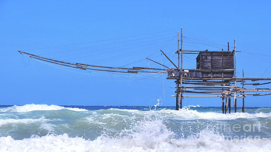 Summer Photograph - Trabocchi coast in Abruzzo with big waves on rough sea - Italy - a trabucco is an old fishing machines famous in south italy sea by Luca Lorenzelli
