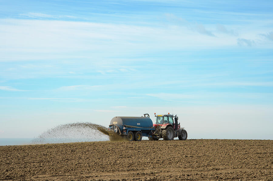 Tractor Pulling Tank Spreading Slurry Over Arable Field Photograph by ...