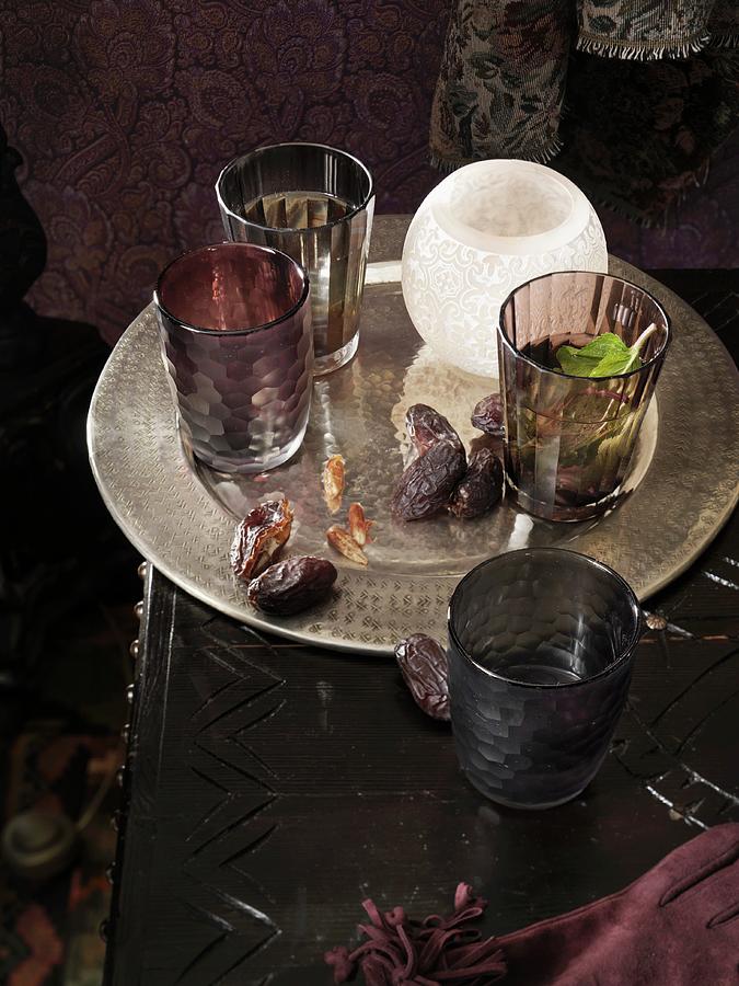 Tray With Dried Dates, Glasses And Tea Light Holders On A Dark Table Photograph by Biglife