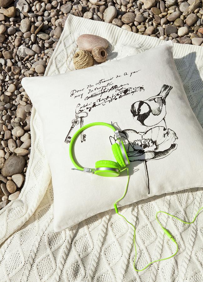 Trendy Headphones In Neon Green On Cushion And Woollen Blanket On Gravel Floor Photograph by Nikky Maier