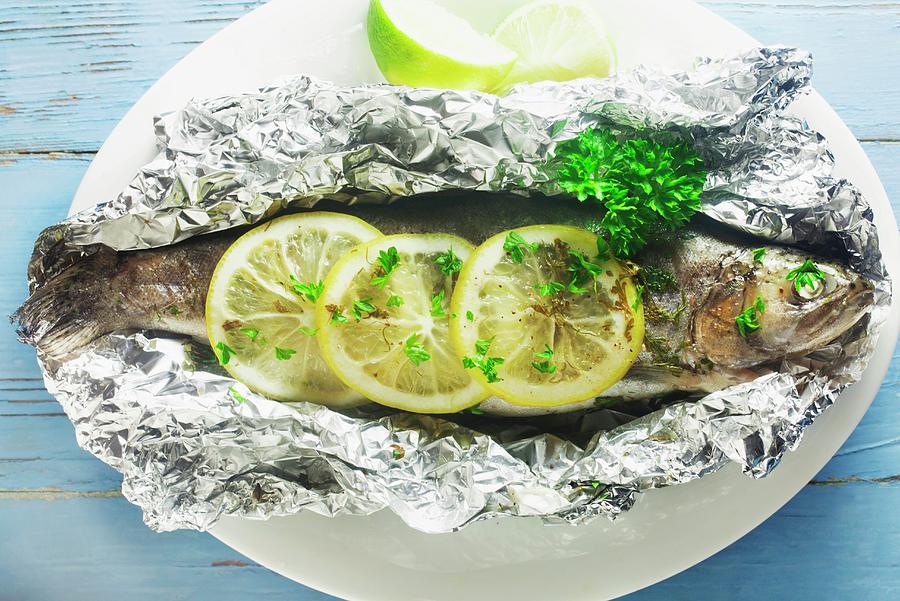Trout With Lemon And Herbs In Aluminium Foil Photograph by Barbara