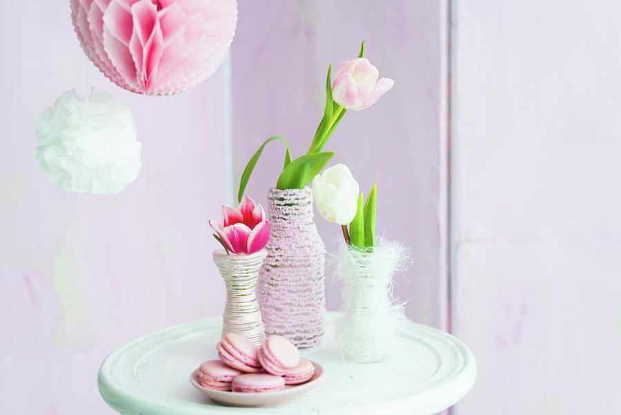 Tulips In Vases Wrapped In Cord Next To Plate Of Pink Macarons Photograph by Ulla@patsy