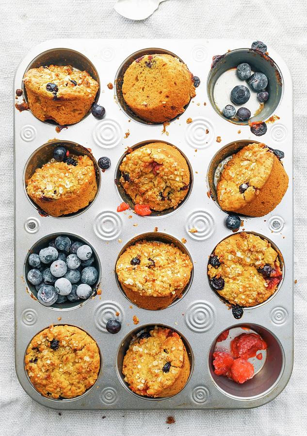 Turmeric And Blueberry Muffins In Their Moulds Photograph by Velsberg