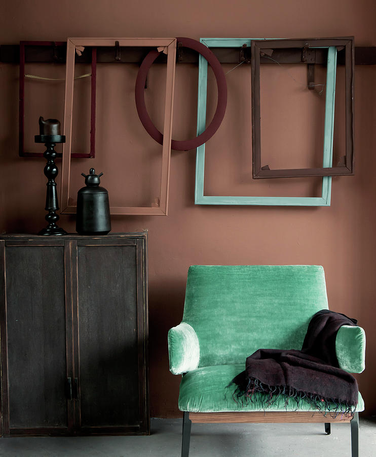 Turquoise Armchair, Wooden Cabinet And Picture Frames On Dusky Pink Wall Photograph by James Stokes