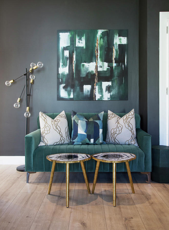 Turquoise Velvet Sofa With Scatter Cushions And Small Side Tables Below Abstract Painting On Wall Photograph by Great Stock!