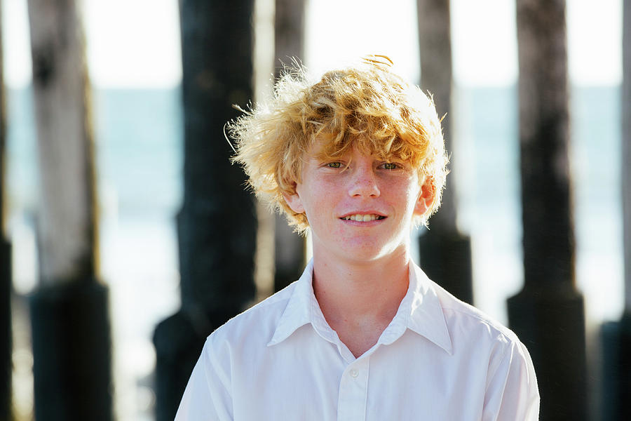 Tween Boy Smiles While Standing In Front Of A Pier Photograph by Cavan ...