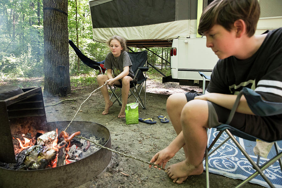 Nature Photograph - Tween Siblings On Family Camping Trip Roast Hot Dogs Over Campfire by Cavan Images