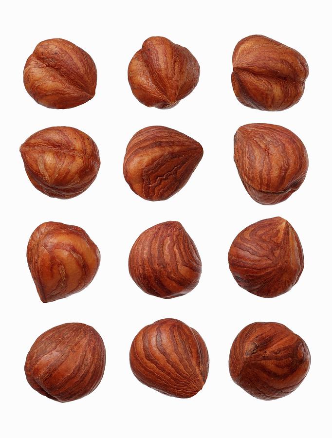 Twelve Hazelnuts On A Wooden Surface Photograph by Krger & Gross