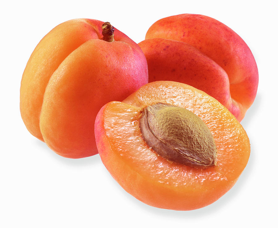 Two Apricots And Half An Apricot On A White Surface Photograph by Fruitbank
