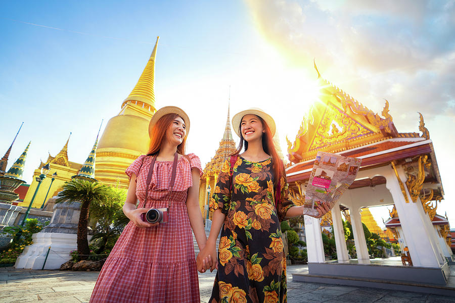 Two asian girlfriends traveling and check location by a map in G Photograph by Anek Suwannaphoom