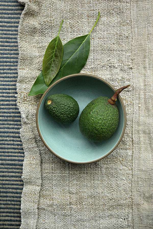 Two Avocados On A Plate Photograph by Emily Brooke Sandor